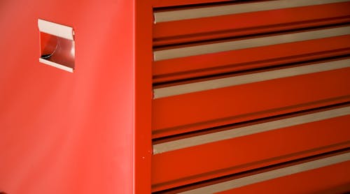 A standing red toolbox with closed drawers.