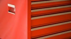 A standing red toolbox with closed drawers.