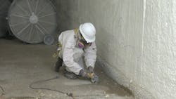 A worker prepares a concrete surface for a rehabilitation project at a wastewater treatment plant. A worker prepares a concrete surface for a rehabilitation project at a wastewater treatment plant.