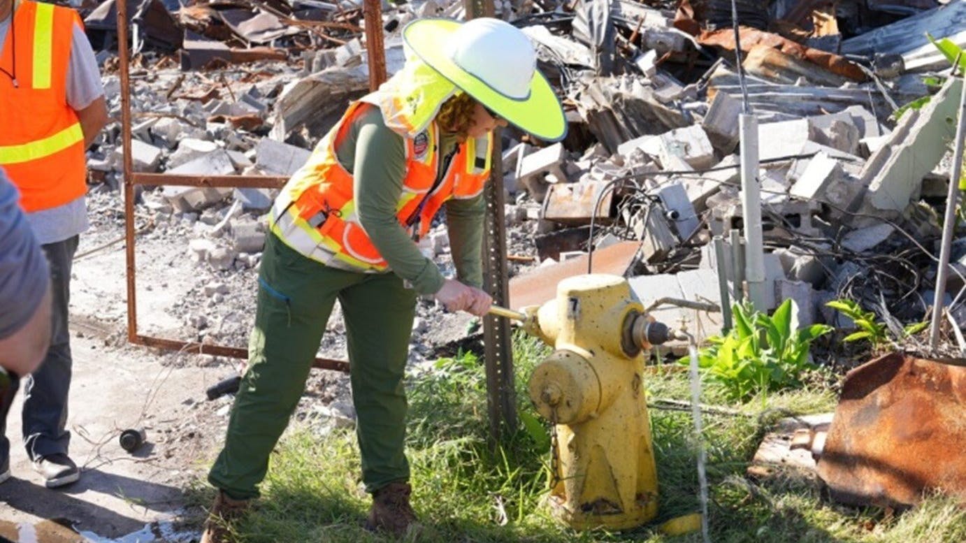 An EPA worker opens a fire hydrant to take a sample.