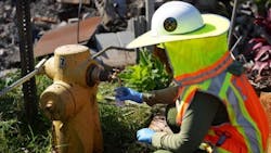 AnEPA worker collects a sample from a fire hydrant for testing and inspection of the distribution system.