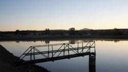 A catwalk over a wastewater treatment lagoon at sunset. A catwalk over a wastewater treatment lagoon at sunset.