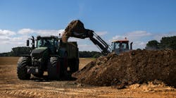 Excavator loads tractor with fertilizer for farming. 57% of wastewater biosolids are land applied as fertilizer in the United States. Excavator loads tractor with fertilizer for farming. 57% of wastewater biosolids are land applied as fertilizer in the United States.